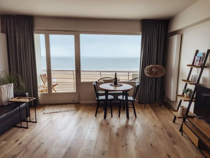 A cozy living room in a beachfront apartment with a stunning ocean view, featuring modern decor