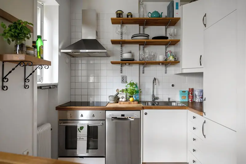 Contemporary small kitchen featuring stainless steel appliances and open shelving