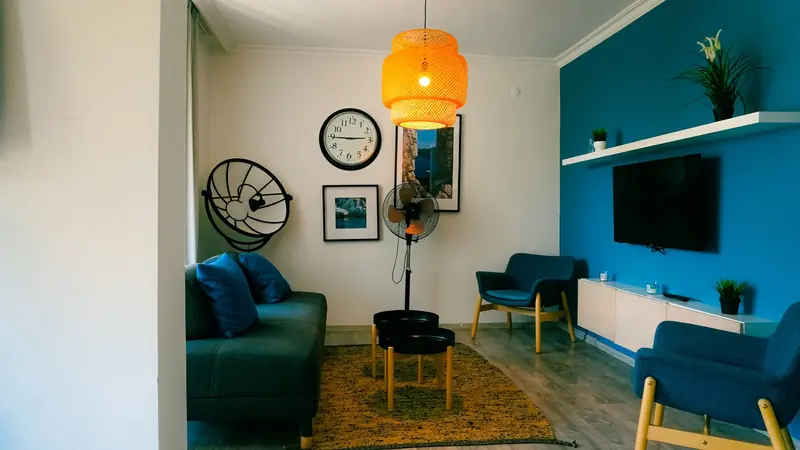 Stylish living room featuring contemporary furniture, blue accents, and a warm ambiance