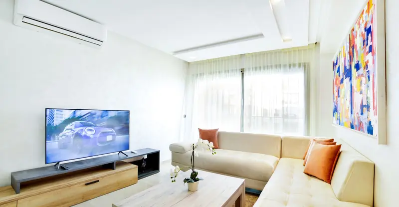 Bright living room featuring modern decor with sofa, TV, and abstract art