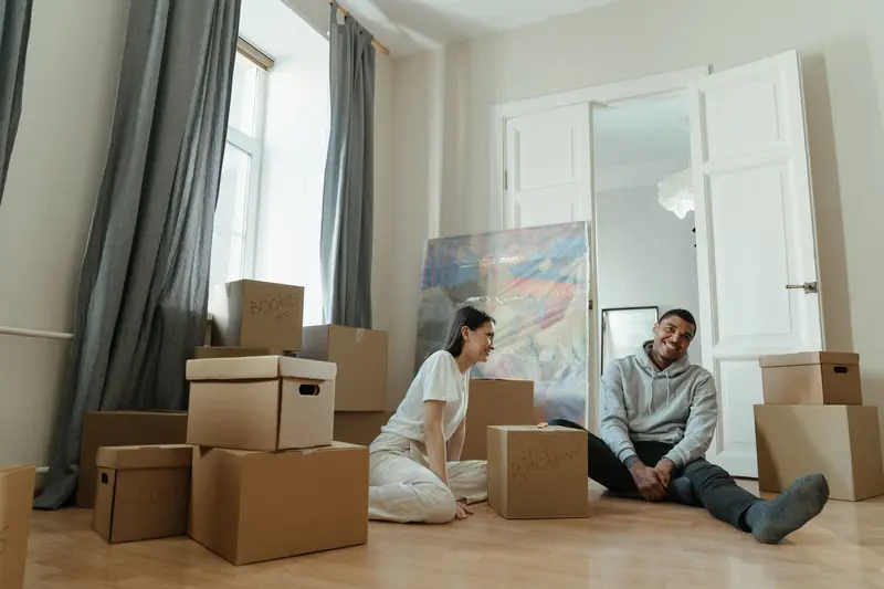 A happy couple surrounded by boxes while moving into a new apartment, symbolizing fresh beginnings